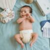 Baby die Popolini wasbare luier Minifit draagt.