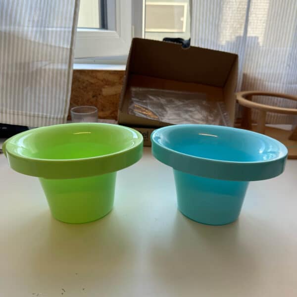 Compact groen en blauw babyplaspotje van Popolini met een brede rand voor extra comfort tijdens het vasthouden.