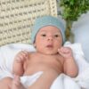 Baby met babymutsje groen met witte stip van Summerville Organic