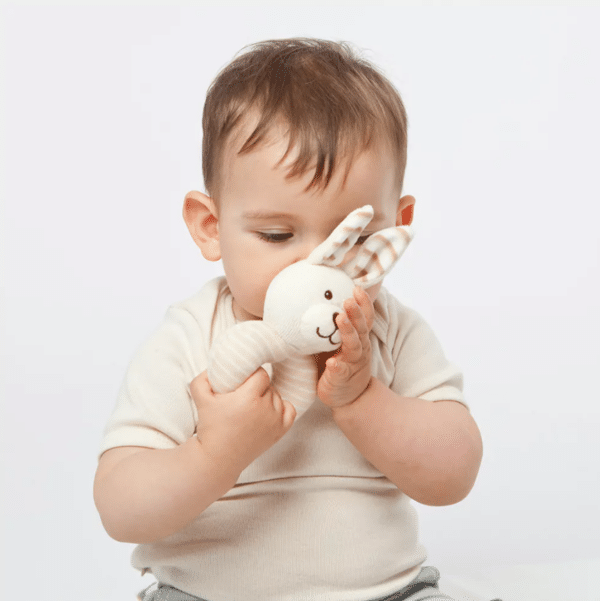 Baby met stoffen rammelaar konijn