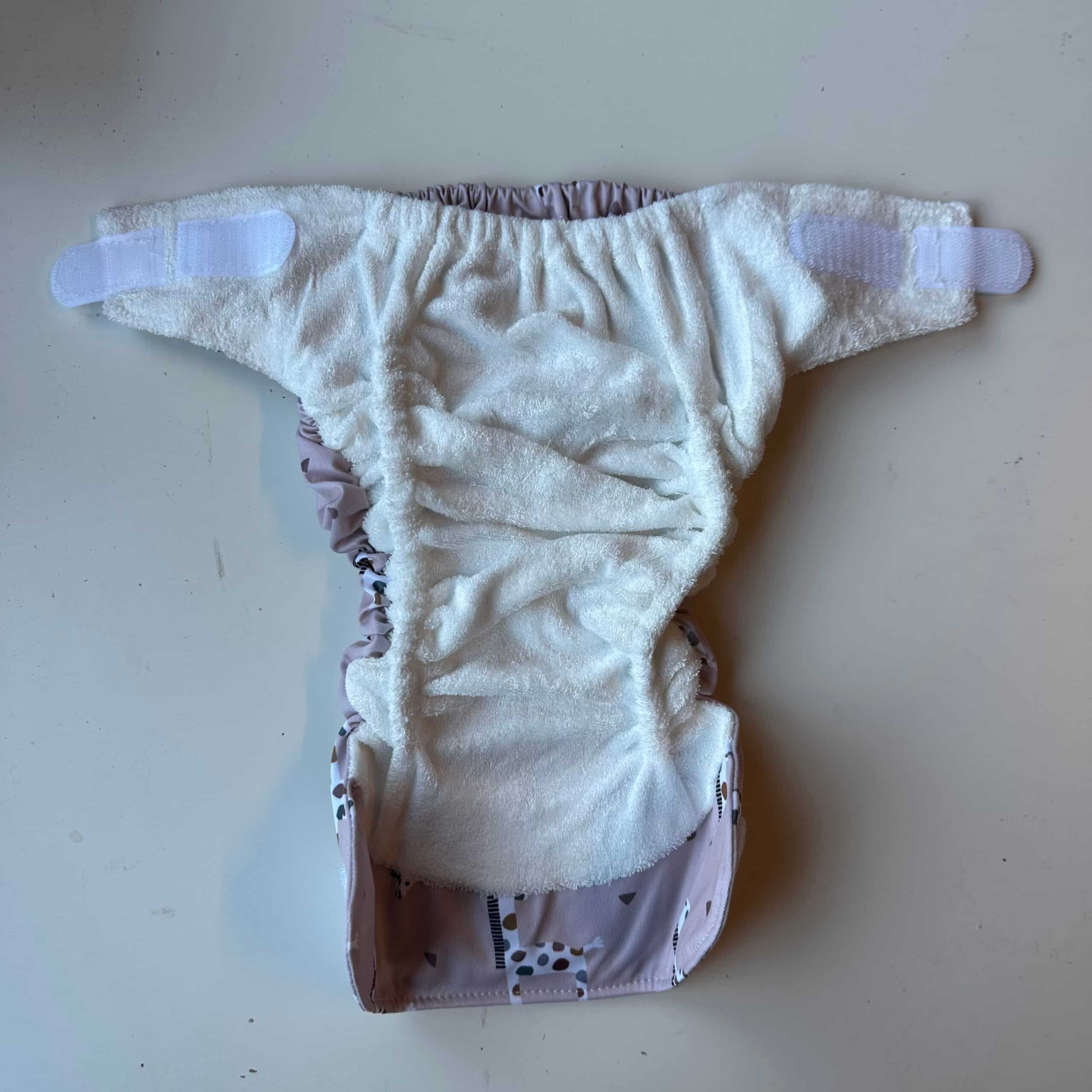 Blümchen wasbare all-in-one luier met klittenband in kleurrijk dessin, herbruikbare AIO luier voor baby’s, lekvrij en zacht, duurzaam alternatief voor wegwerpluiers bij Pure Start.