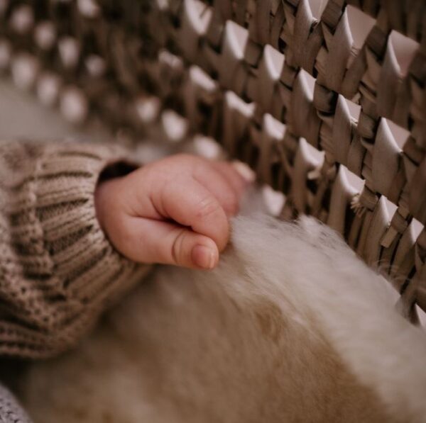 Schapenvacht met babyhandje.