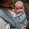 Baby in geweven draagdoek van Pure BAby Love in kleur sea blue. Gemaakt van biologisch katoen.