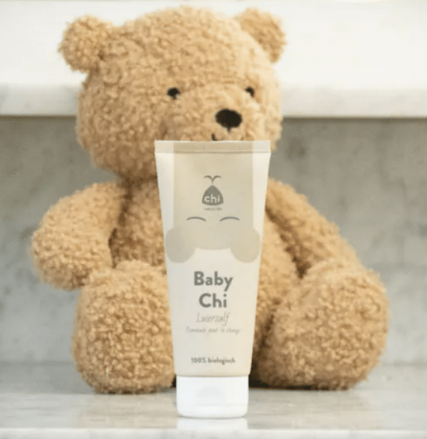 Tube luierzalf van Chi naast een knuffelbeertje.