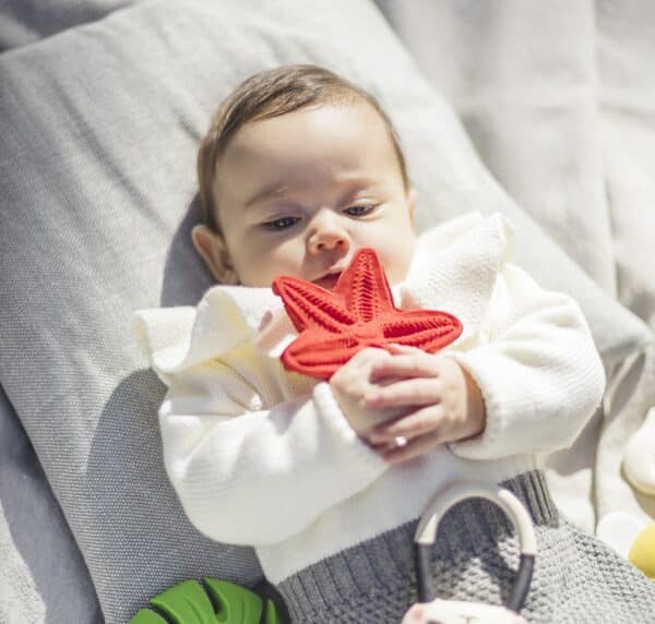 Baby met bijtspeeltje rode zeester.